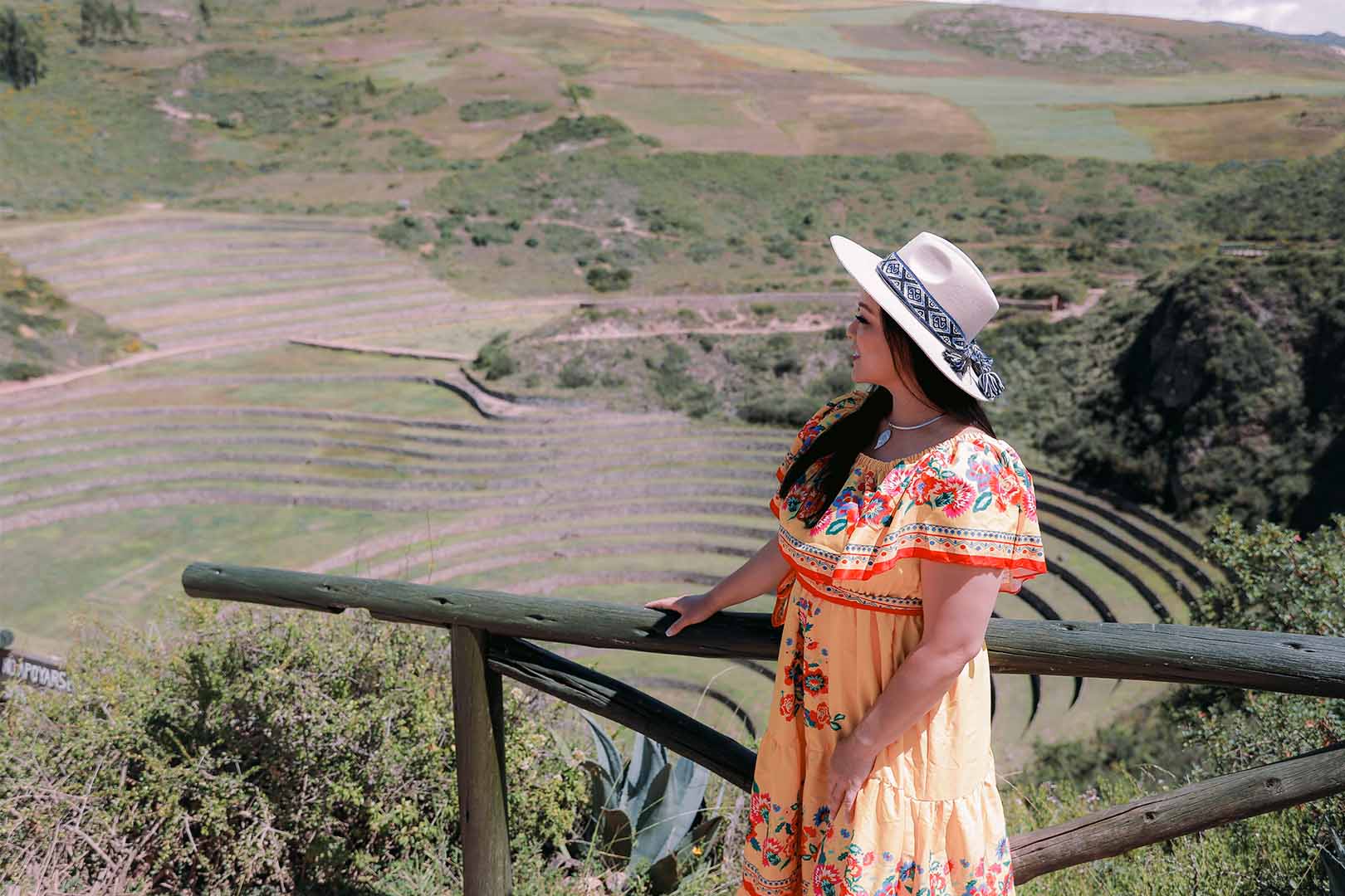 Maras Salt Mines photo A tourist stands admiring the terraced salt pools of the Maras Salt Mines in Peru